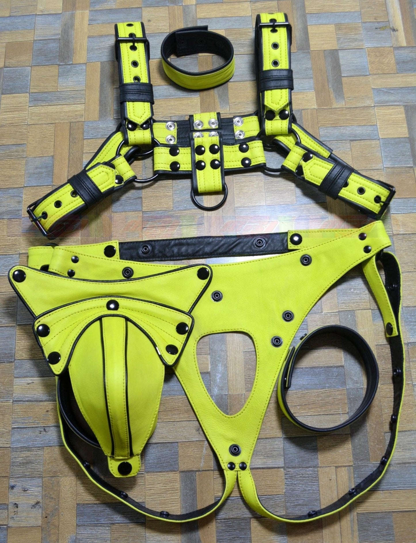 Men's leather harness with adjustable buckle, yellow and black design, includes jock and arm bands.